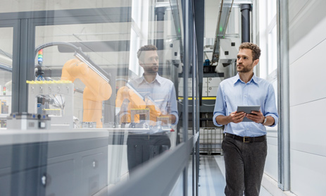 Man observing and walking through high-tech facility 