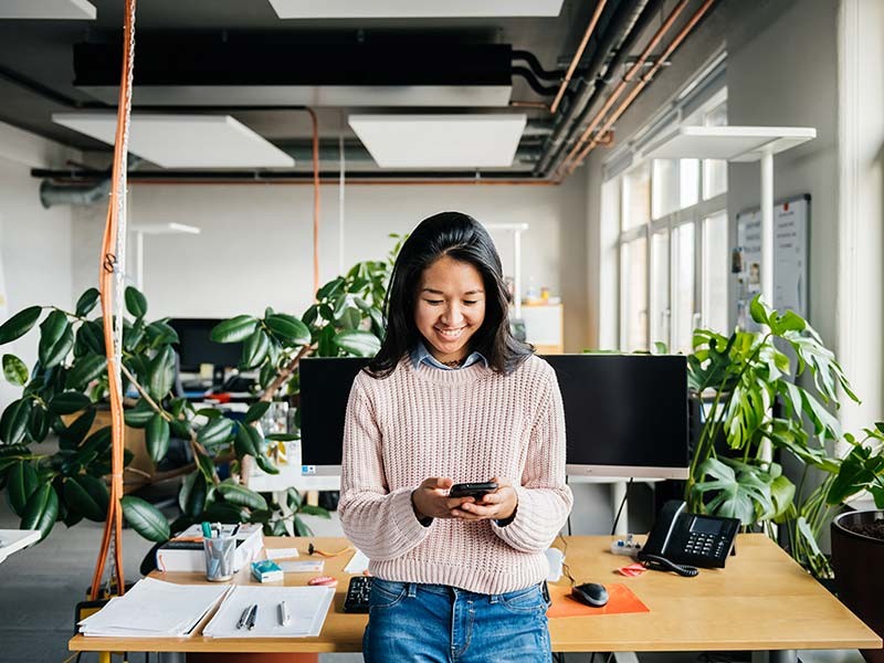 Happy employee in a green office, smiling.