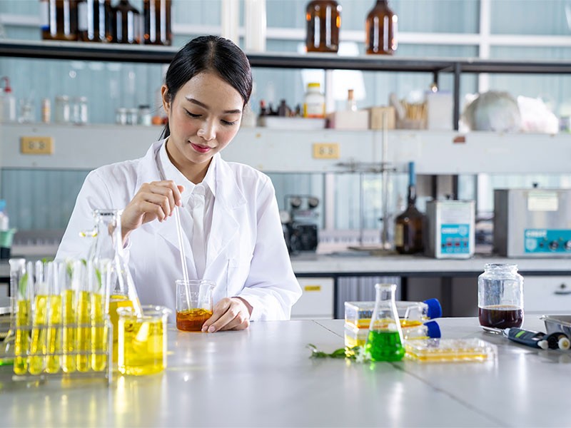 A lab specialist using a beaker and doing a test. 