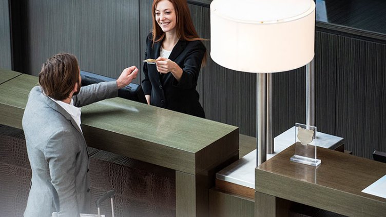 Female receptionist giving credit card to businessman 