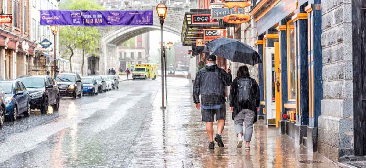 Two people going somewhere in the rainfall holding umbrella 