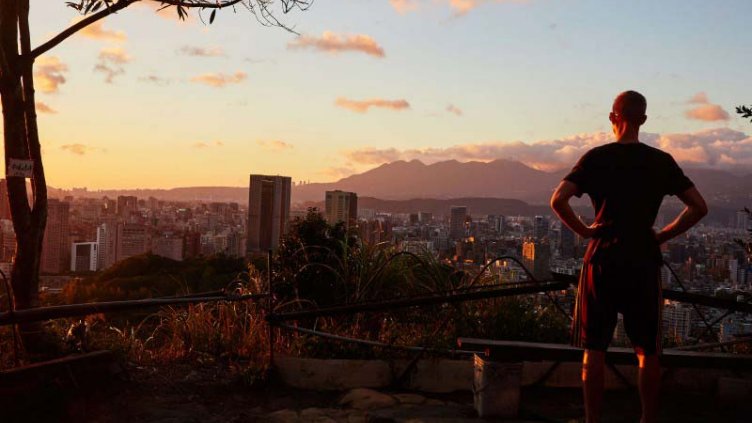 A man looking towards the smart city buildings at the time of sunrise