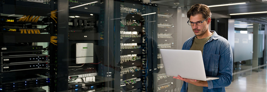 A person using laptop in a server room