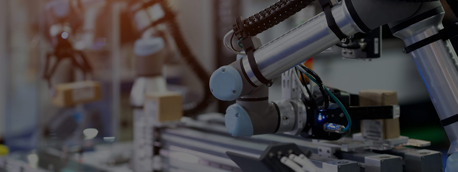 Focused shot of industrial robot placing box on conveyer belt