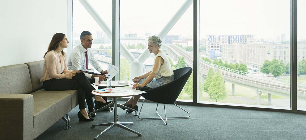 Investors discussing about the gig economy while sitting inside a real estate office building